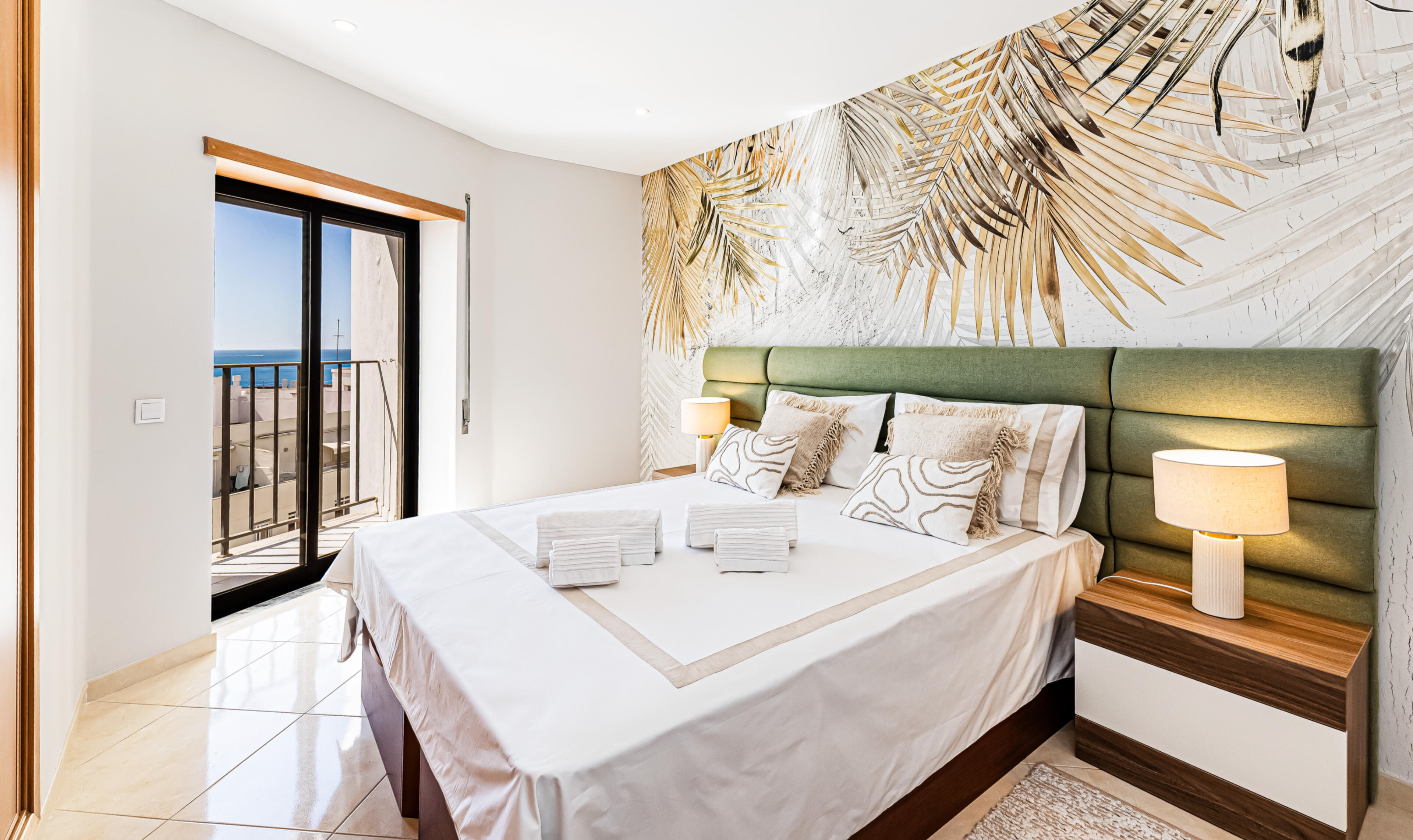 Bright bedroom with ocean view balcony and comfortable bedding in Algarve apartment