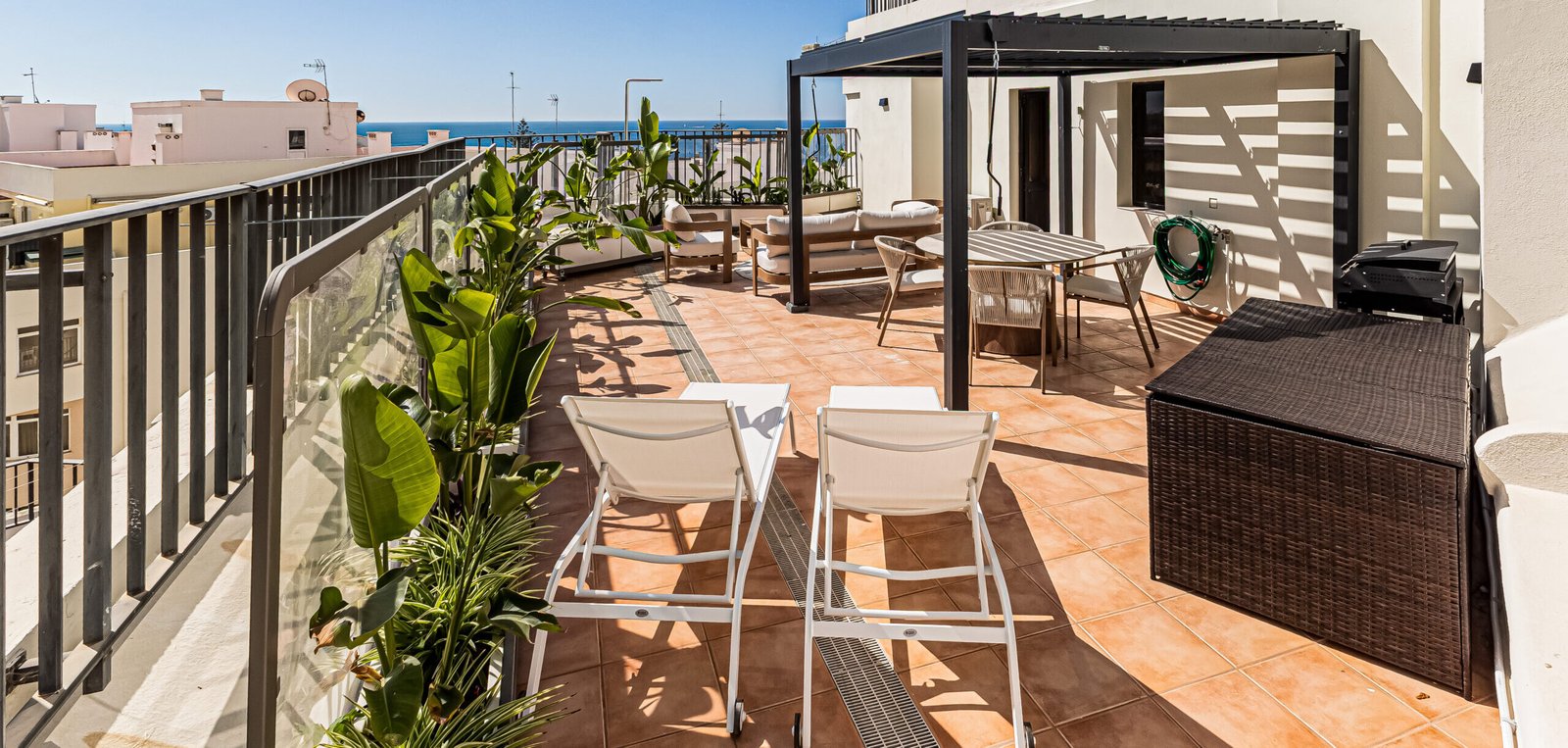 Grande terraço privado de 84 m² com pérgola, zona de refeições, espreguiçadeiras e vista panorâmica para o mar no Paraíso de Pêra, Armação de Pêra, Algarve.
